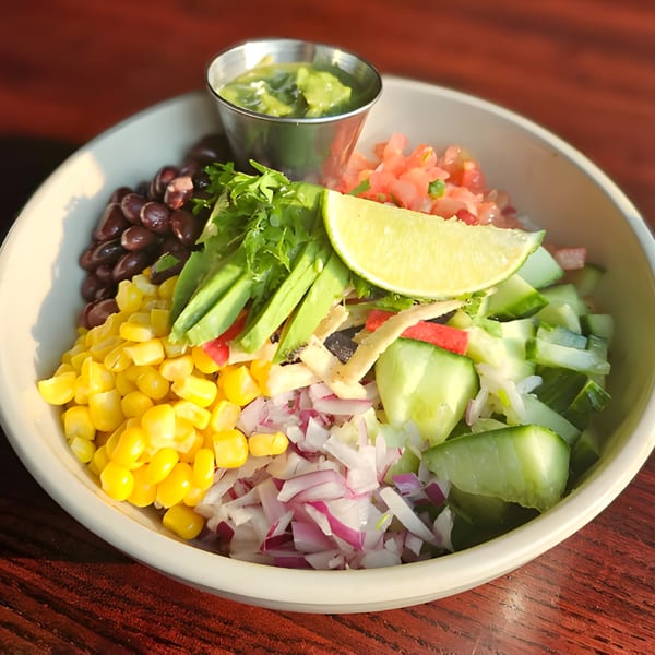 Colorful Wyld Pines American cuisine salad bowl with corn, beans, avocado, and lime.